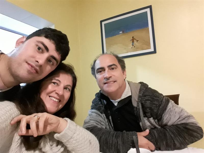 #pracegover: o aluno Murilo em uma foto com seus pais, todos estão sorridentes