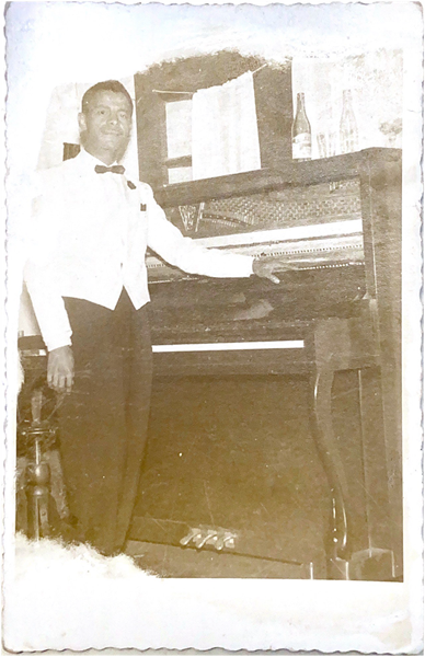 Alfredo Custódio posando ao lado de um piano. Fonte: Arquivo Histórico Regional.